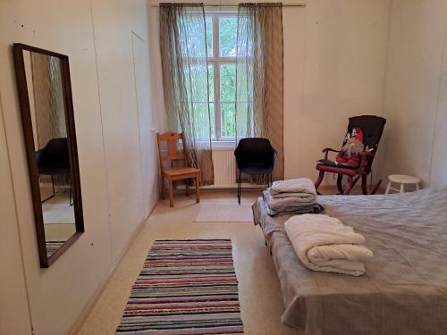 1 Schlafzimmer mit 2 Betten, einem Spiegel und Stühlen in der Unterkunft Tolvi in Harjavalta