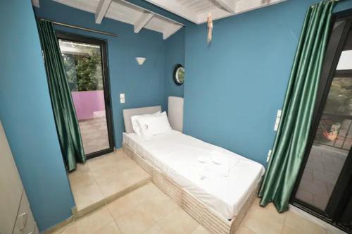 a room with a bed in a room with blue walls at Anastasias Villa in Kastro Kyllini