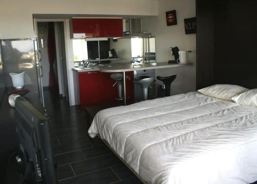 Cet appartement comprend une chambre avec un lit blanc et une cuisine. dans l'établissement Studio 567, Port Nature 5 au village naturiste, au Cap d'Agde