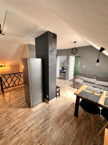 a kitchen and living room with a stainless steel refrigerator at Szmaragdowe Apartamenty in Polańczyk