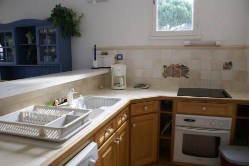une cuisine avec un évier et une cuisinière dans l'établissement Appartement Duplex 301 Tennis Village 6 Personnes, au Cap d'Agde