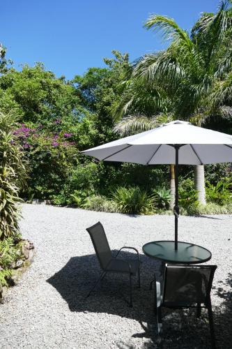a table and a chair with an umbrella and a table and a chair at Casitas Vista Verde in Bajo Boquete