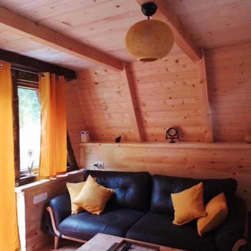 a living room with a black leather couch in a cabin at Family S house - Komarnica in Šavnik