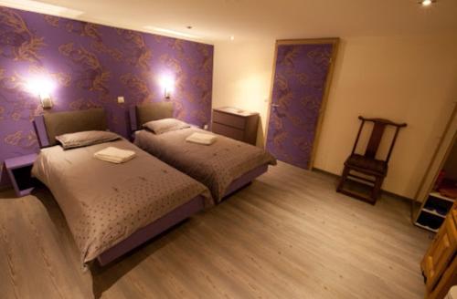 2 bedden in een kamer met paarse muren bij Hotel JiuDing in Hochdorf