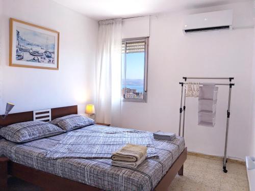 Schlafzimmer mit einem Bett und einem Fenster in der Unterkunft 1Bdrm APT With Panoramic View of Sea and Mountains in Tiberias