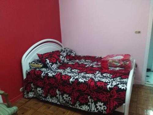 um quarto com uma cama com um edredão vermelho e branco em مفيدا no Cairo