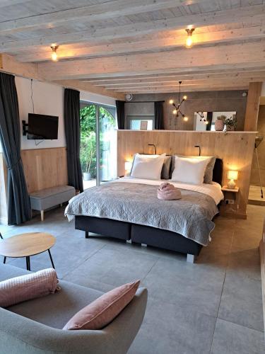 a bedroom with a large bed with a wooden ceiling at Domein Den Buiten Bed And Breakfast DnD in Sint-Niklaas