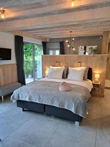 a bedroom with a large bed with a wooden headboard at Domein Den Buiten Bed And Breakfast DnD in Sint-Niklaas