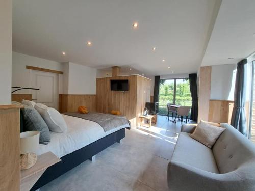 a bedroom with a large bed and a couch at Domein Den Buiten Bed And Breakfast DnD in Sint-Niklaas
