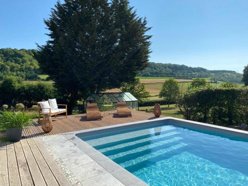 - une piscine sur une terrasse avec des chaises et un arbre dans l'établissement Gîte piscine jacuzzi privatisés Clos Valentin, à Freulleville