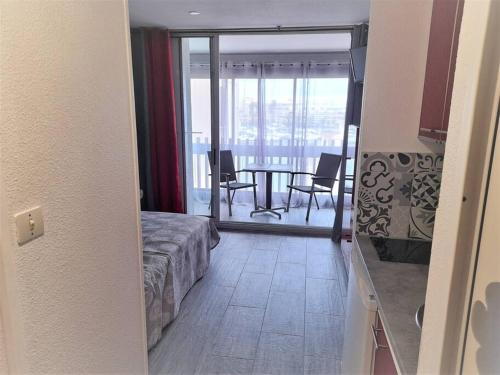 Cette chambre comprend un lit et offre une vue sur une salle à manger. dans l'établissement Studio 309, Port Vénus au village naturiste, au Cap d'Agde