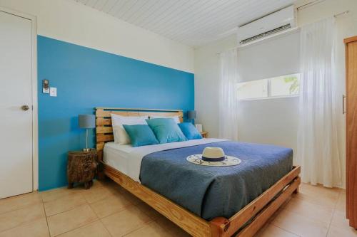 a blue bedroom with a bed with a hat on it at Unbounded Horizons:Serene home with Panoramic view in Savaneta