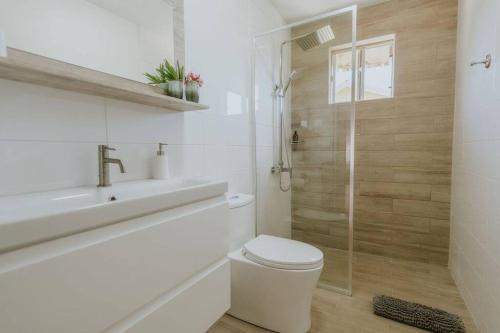 a bathroom with a toilet and a sink and a shower at Unbounded Horizons:Serene home with Panoramic view in Savaneta
