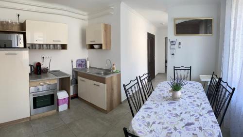 een keuken en eetkamer met een tafel en stoelen bij Lavender Garden Apartment in Debrecen