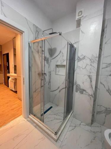 a bathroom with a shower with marble walls at Comfort,excellence. in Kamëz