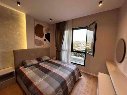 a bedroom with a bed and a large window at Comfort,excellence. in Kamëz