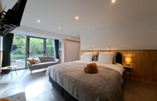 a bedroom with a bed with a stuffed animal on it at Domein Den Buiten Bed And Breakfast DnD in Sint-Niklaas