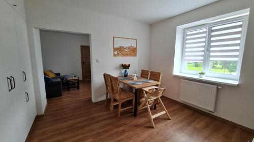 a dining room with a table and chairs and a window at Horský apartmán Karlovice in Karlovice
