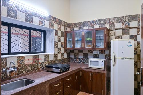 uma cozinha com um frigorífico e um lavatório em Heaven Villa em Panchgani