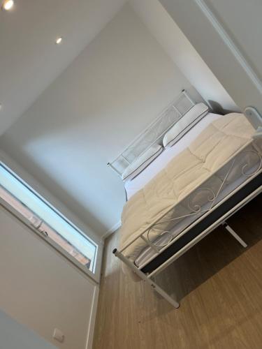 Mini maison - Oncy détend في Oncy: سرير صغير في غرفة صغيرة مع نافذة