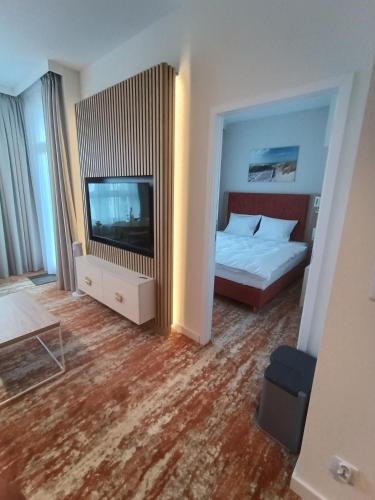 a bedroom with a bed and a flat screen tv at Bel Mare Aqua 2 and Garden F104 in Międzyzdroje