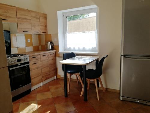 a small kitchen with a table and two chairs at Apartament nad Węgorapą in Węgorzewo