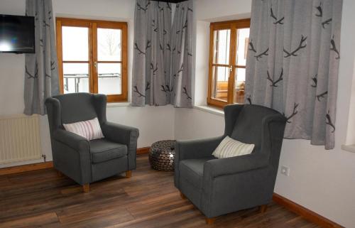2 Stühle und ein TV im Wohnzimmer in der Unterkunft Das Glaagut - Familie Hain in Hochfilzen