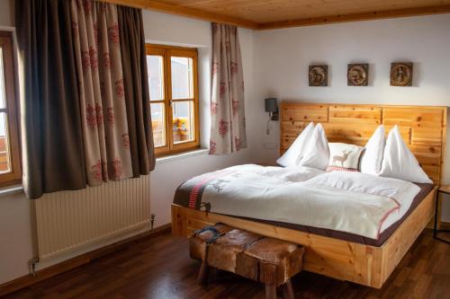 een slaapkamer met een groot bed met een houten hoofdeinde bij Das Glaagut - Familie Hain in Hochfilzen