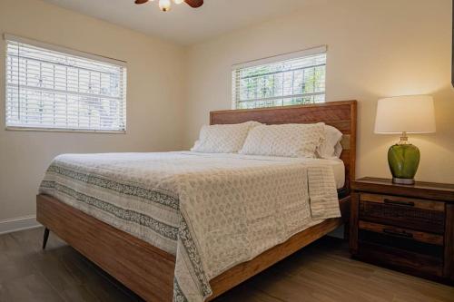 a bedroom with a bed and a lamp and two windows at Cozy 3Bdr home in the heart of Tampa in Tampa