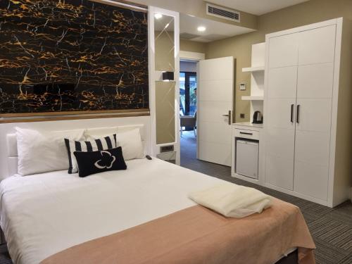 a bedroom with a large white bed and a kitchen at Mia Berre Hotels in Istanbul