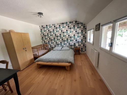 een slaapkamer met een bed en een houten vloer bij Appartement atypique in Eslettes