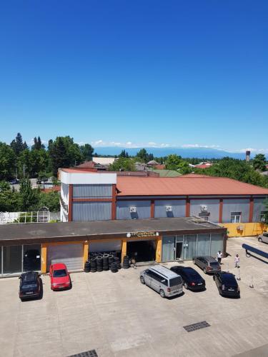 a large building with cars parked in a parking lot at Recalls in Samtredia