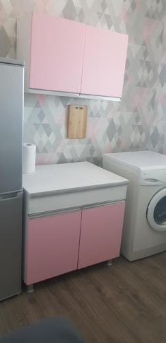a bathroom with a pink sink and a washing machine at Recalls in Samtredia