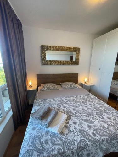 a bedroom with a bed with a blue and white bedspread at Byla Sun Day Apartament in Byala