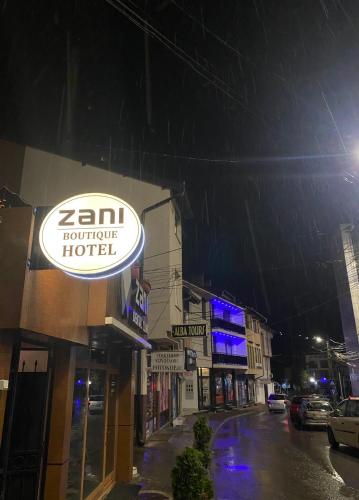 a sign for a hotel on a city street at night at Zani Boutique Hotel in Prizren