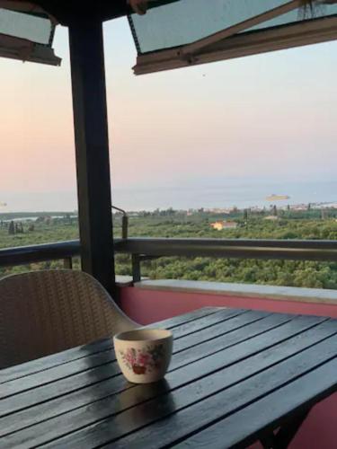 a cup sitting on a wooden table with a view at Anastasias Villa in Kastro Kyllini