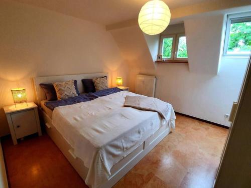 um quarto com uma cama grande com duas mesas e um candeeiro em Helle Ferienwohnung - Südeifel em Ammeldingen