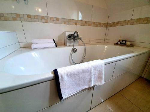 a bathroom with a bath tub with towels on it at Helle Ferienwohnung - Südeifel in Ammeldingen