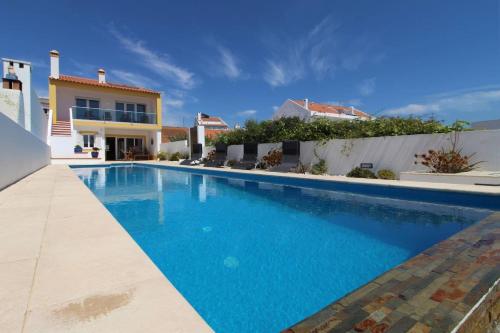 a swimming pool in front of a house at Fonte dos Pássaros in Vila Nova de Milfontes