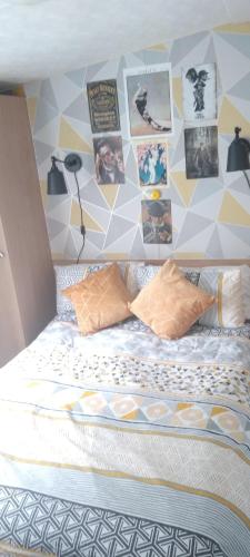 uma cama com uma parede com fotografias em Coghurst Hall themed static caravan em Westfield