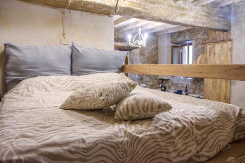 Una cama con dos almohadas encima. en IL NIDO DI MATILDE _monolocale design sul fiume_, en Rossena