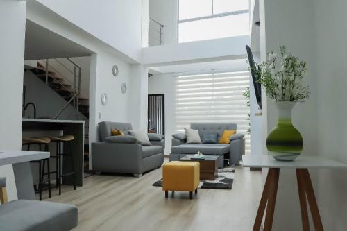 a living room with a couch and a yellow chair at Apartamentos cómodos en Milan zona G in Manizales