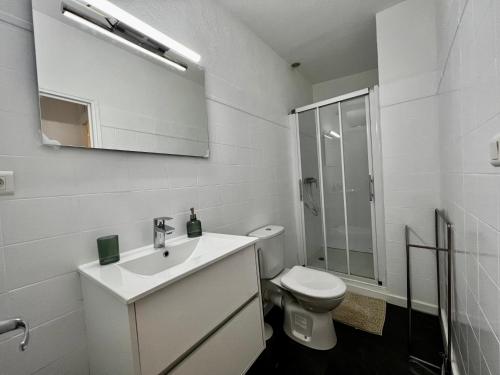 a white bathroom with a sink and a toilet at Collioure, centre ville, joli T2 in Collioure