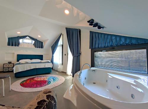 baño grande con bañera y cama en villa nerit, en Fethiye