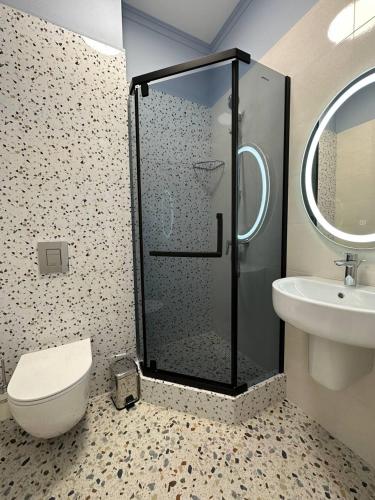 a bathroom with a shower and a toilet and a sink at Five Hotel in Astana