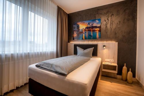 a bedroom with a large bed and a large window at Hotel Monopol in Gelsenkirchen