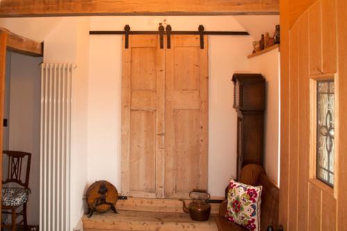 Habitación con puerta de madera en la pared en The Cottage, en Cross in Hand