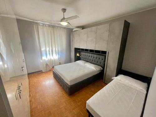 a bedroom with two beds and a ceiling fan at THE APARTMENT - HOME in Gerenzano