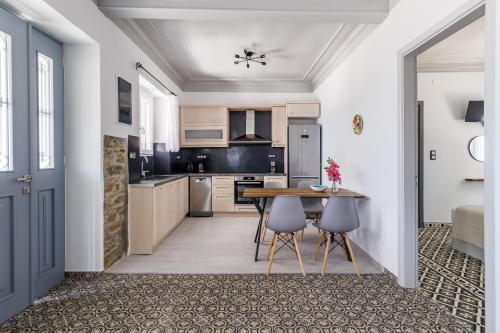 a kitchen with a table and chairs in a room at Afrodite's House in Glóssa