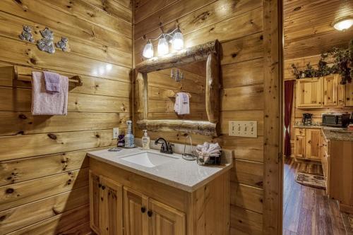 a bathroom with a sink and a mirror at Pooh Bear, Hot Tub, WIFI, 685 FREE tickets each paid day!!! in Sevierville